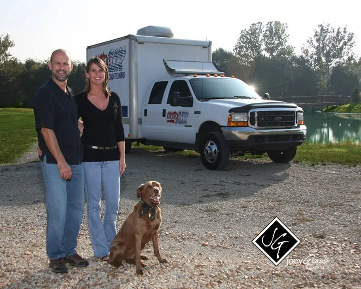 Arkansas Air owner with his wife and dog in front of work truck